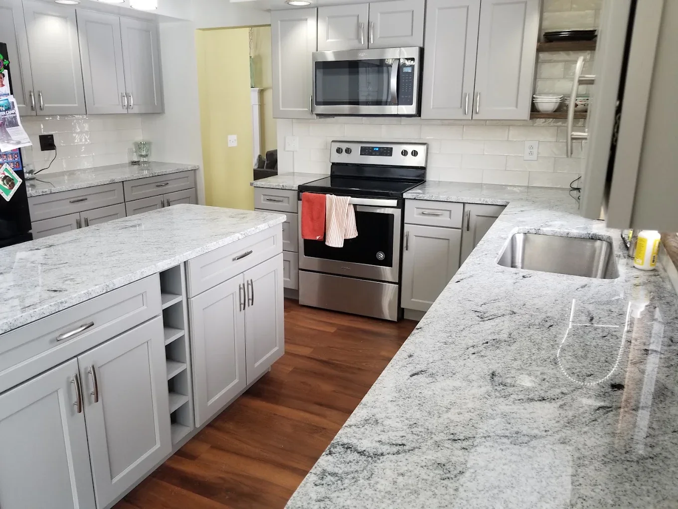 Remodeled white kitchen with stone peninsula