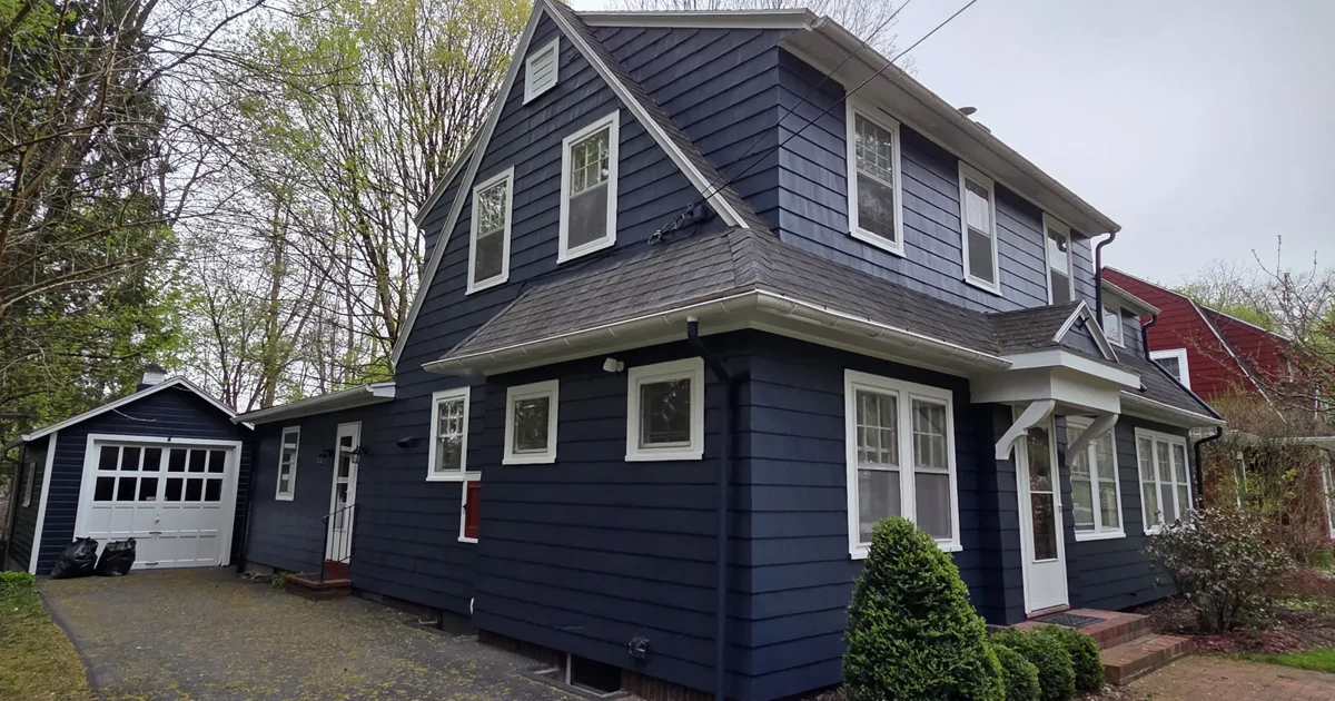 Completed Rochester-area home exterior with navy siding and white window trim