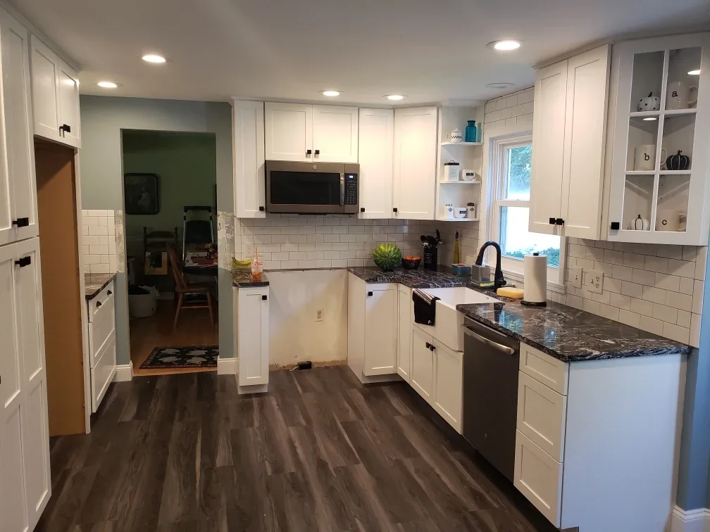 Bright remodeled kitchen with white cabinets and stone counters