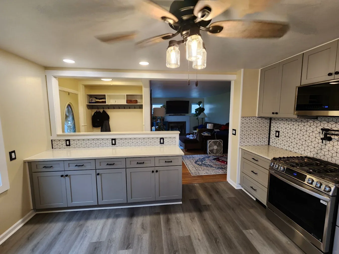 Remodeled kitchen with gray cabinets and peninsula