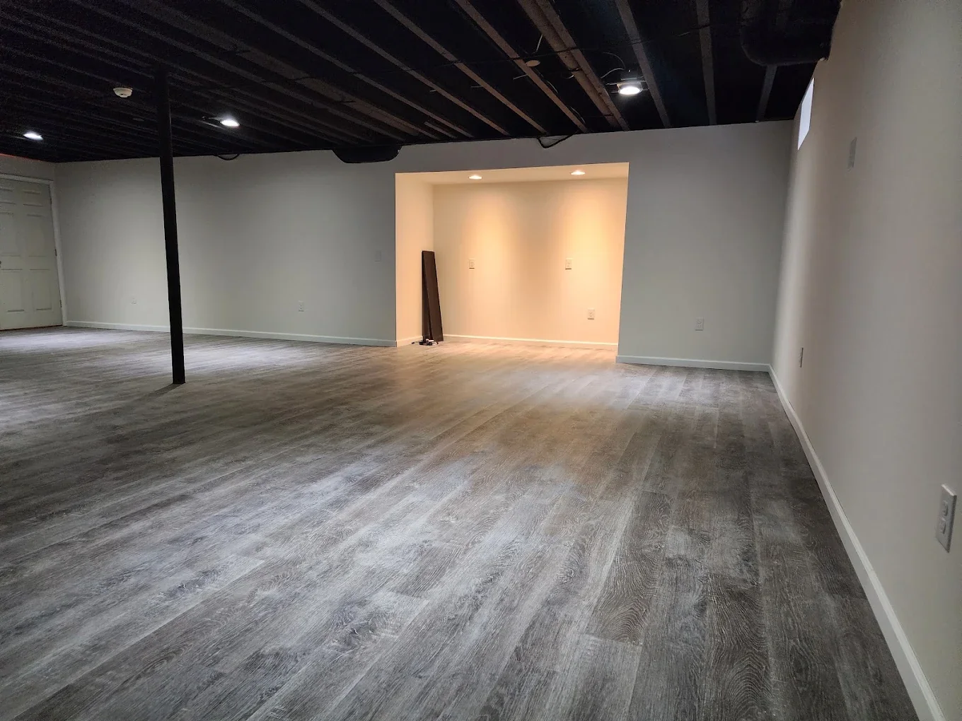 Large basement recreation room with dark ceiling