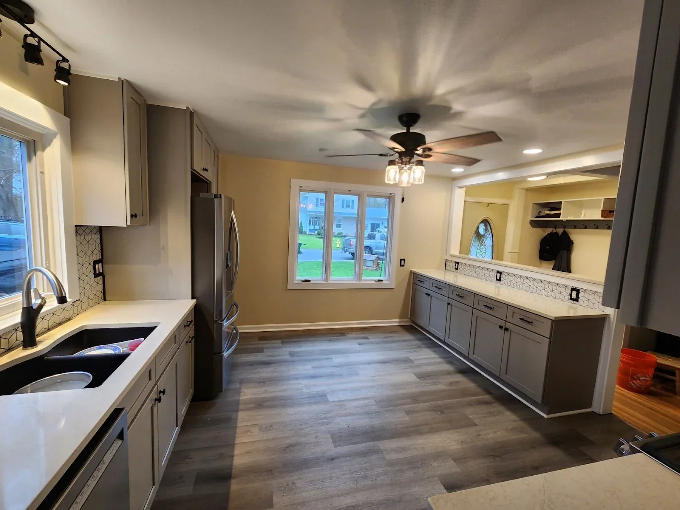 Long remodeled kitchen with gray cabinets and new flooring