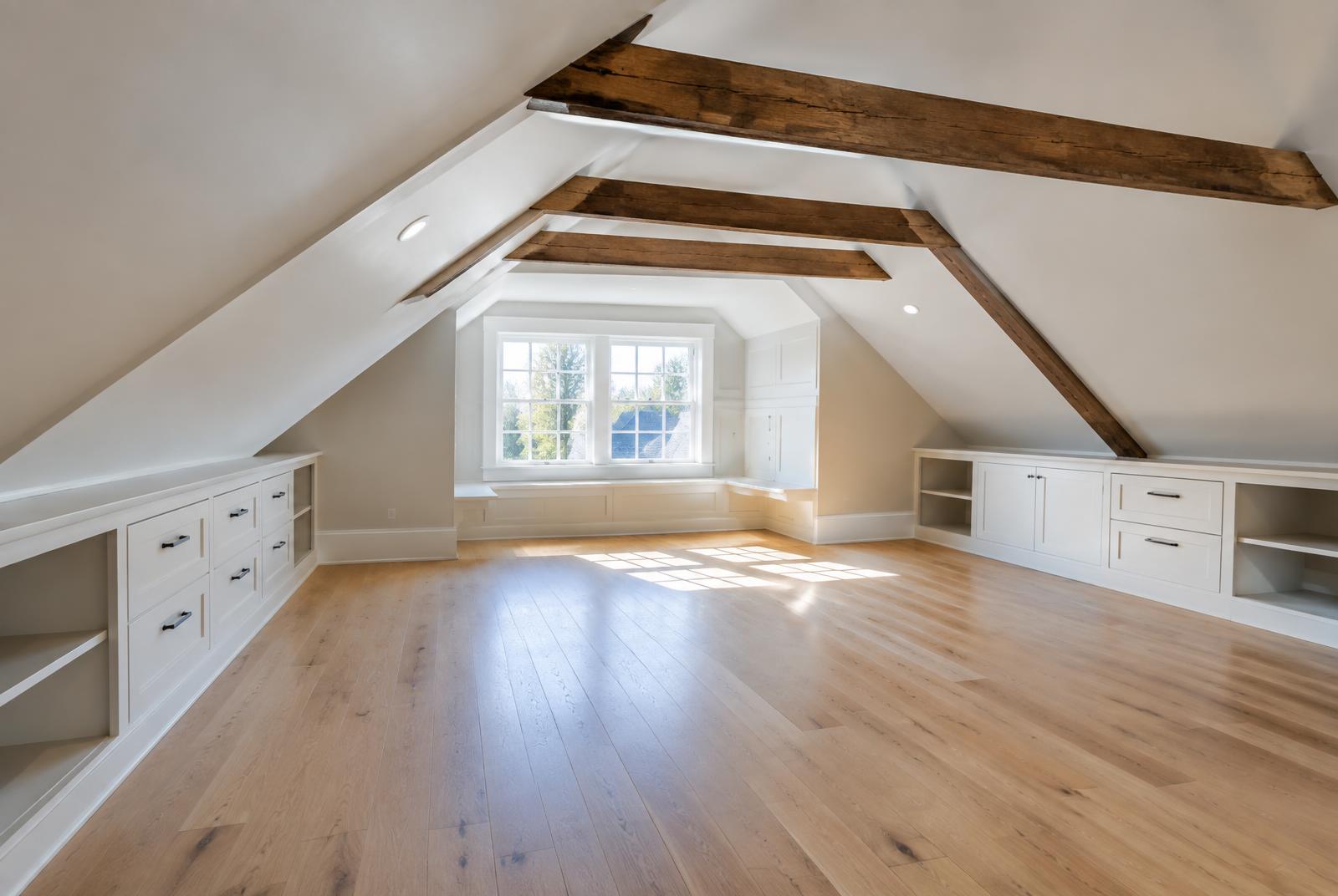 Finished Rochester attic with sloped ceilings, exposed beams and built-in storage